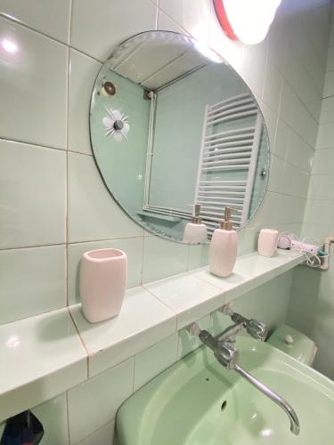 uma casa de banho com um espelho, um lavatório e uma banheira em Davit's Apartment 21 em Tbilisi