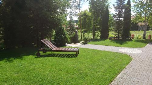 a bench sitting in the grass in a park at Mazurskie Siedlisko Langen in Mrągowo
