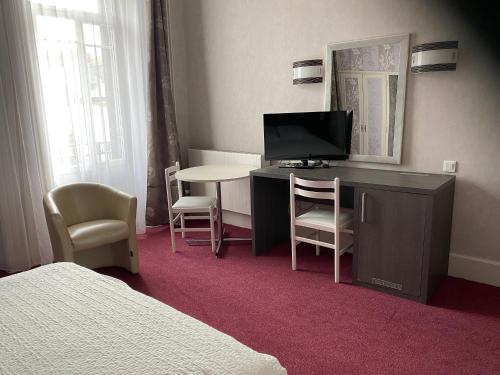 TV a/nebo společenská místnost v ubytování Hôtel de Paris