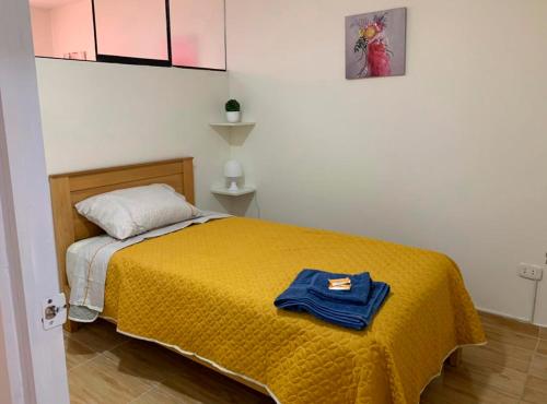 1 dormitorio con 1 cama con manta amarilla en Acogedor departamento amoblado en san miguel, primer piso, wifi., en Lima
