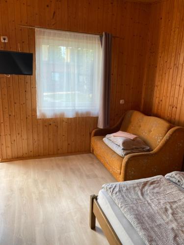 a room with a bed and a window and a couch at Orle Gniazdo domki in Stegna