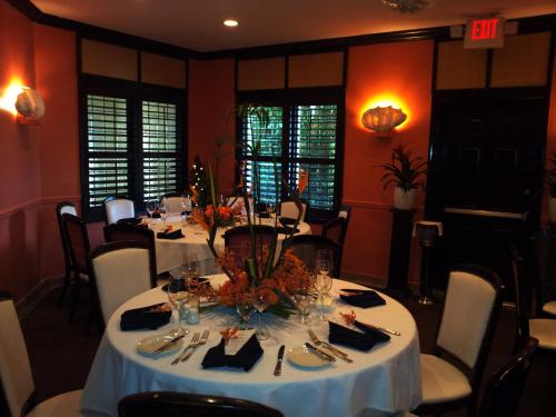 a dining room with a table with white table cloth at The Caribbean Court Boutique Hotel in Vero Beach