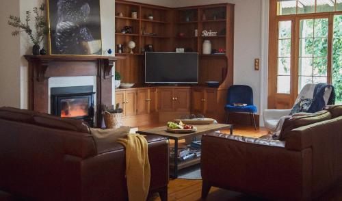 Una sala de estar con dos sofás y una chimenea. en CLAYFIELD HOMESTEAD - rustic country accommodation, en Bishopsbourne