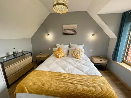 a bedroom with a bed with yellow and white pillows at Gîte des Ouches 