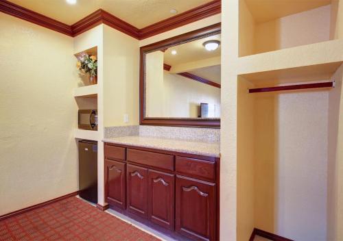 a kitchen with brown cabinets and a mirror at Welcome Inn in Inglewood