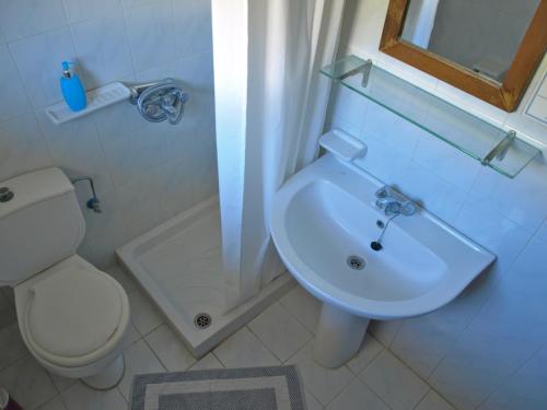 a bathroom with a white toilet and a sink at Castellania Hotel Apartments in Livadia