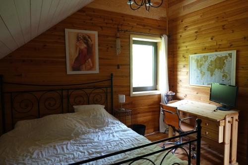 Schlafzimmer mit einem Bett und einem Schreibtisch mit einem Computer in der Unterkunft Bel Air en Chartreuse in Saint-Pierre-de-Chartreuse