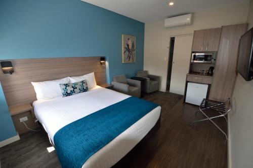 una camera d'albergo con un grande letto e una sedia di 105 On The Park a Bordertown