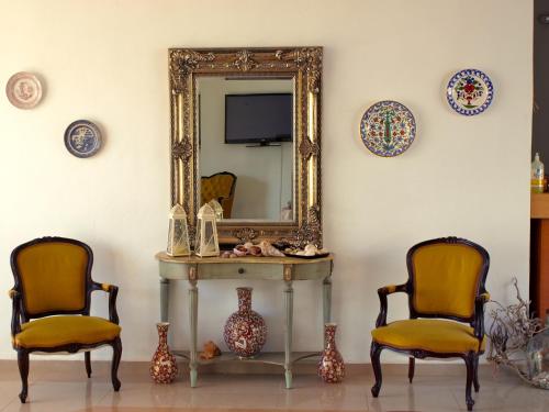 two chairs and a table in front of a mirror at Castellania Hotel Apartments in Livadia