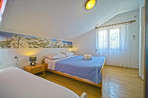 a bedroom with two beds and a window at Guest House Matana Pomena in Pomena