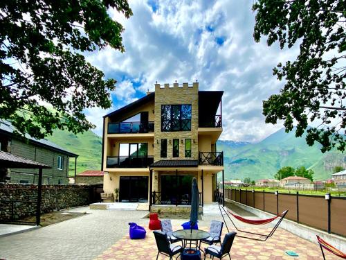 a house with a table and chairs in front of it at Besami Hotel in Stepantsminda