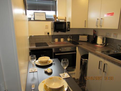 Tomatin的住宿－Drovers Studio Apartment，厨房配有一张桌子和两杯葡萄酒