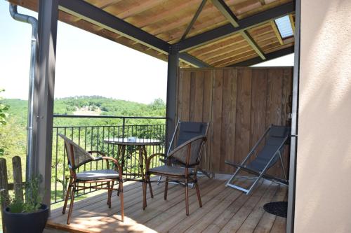 a patio with chairs and a table on a deck at Domaine de La Rhonie in Meyrals