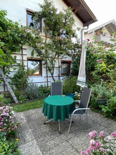 a green table and two chairs and an umbrella at Ferienwohnungen Gmeiner in Bad Endorf