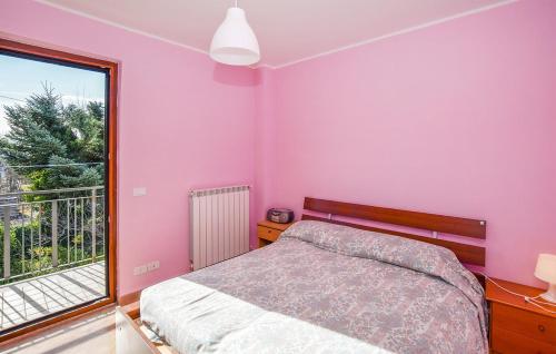 Ca' di Lena في Belmonte in Sabina: غرفة نوم بجدران وردية وسرير ونافذة