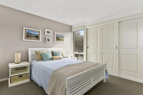 Un dormitorio blanco con una cama y una ventana. en Esperanza, en Apollo Bay