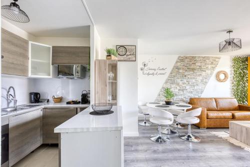 cocina y sala de estar con sofá y mesa en L'éclat Verdoyant de Noisy - Jardin, en Noisy-le-Grand