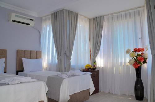 イスタンブールにあるホテル ヤスミンのベッド2台と花瓶が備わるホテルルームです。