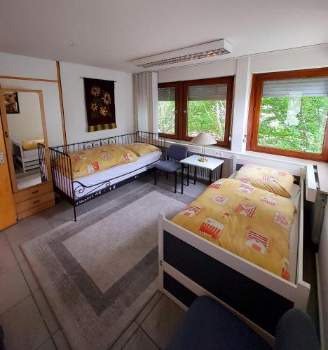 a bedroom with two beds and a living room at Pension beim Kastell in Sulz am Neckar