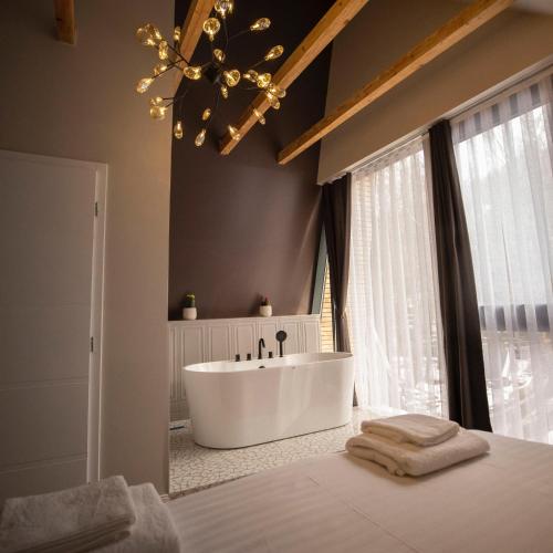 a bathroom with a tub and a large window at Pine Villas Brezovice in Brezovica