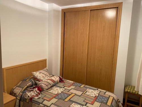 a bedroom with a bed and a wooden door at Jardín de Boiro in Boiro