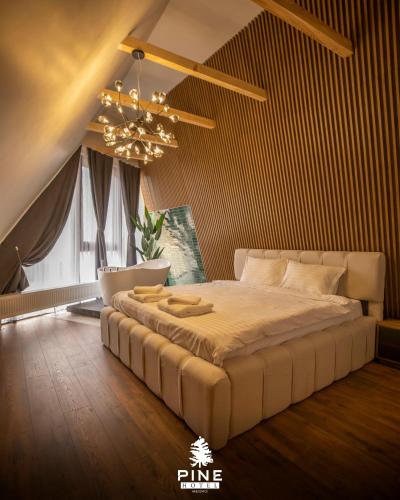 a bedroom with a bed and a chandelier at Pine Villas Brezovice in Brezovica