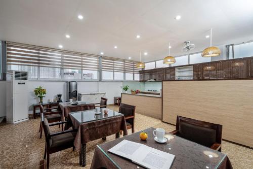 a restaurant with tables and chairs and a kitchen at 그레이스 호텔 Grace Hotel & Residence in Hanoi