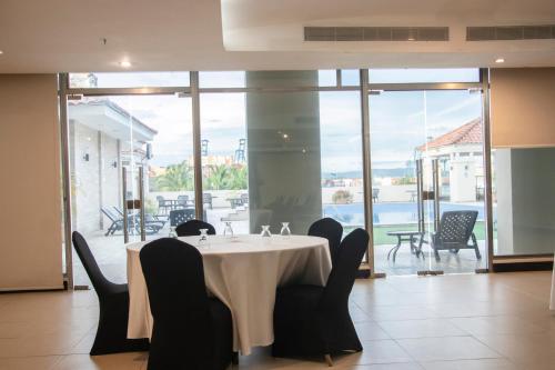 a dining room with a table and chairs and a large window at Radisson Colon 2,000 Hotel & Casino in Colón