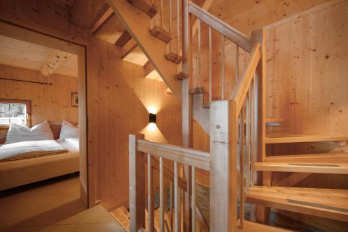 a staircase in a log cabin with a bed and a bedroom at Bergspektive - Haus Alpenspa in Rieding