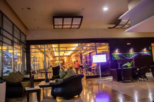 a lobby with chairs and a person standing in a building at Radisson Colon 2,000 Hotel & Casino in Colón