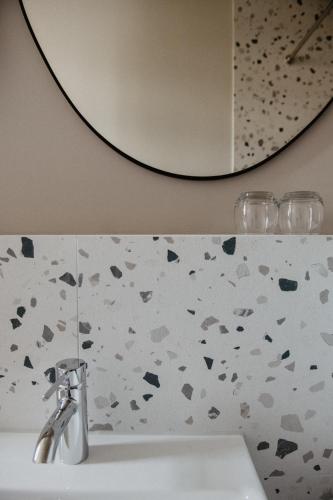 a bathroom sink with a silver faucet and a mirror at Hotel Schloss Teutschenthal in Teutschenthal