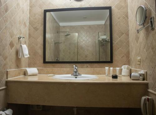 a bathroom with a sink and a mirror at Radisson Colon 2,000 Hotel & Casino in Colón