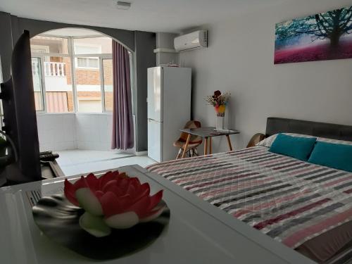 a room with a table with a flower in a bowl at ESTUDIO EMMA in Torrevieja