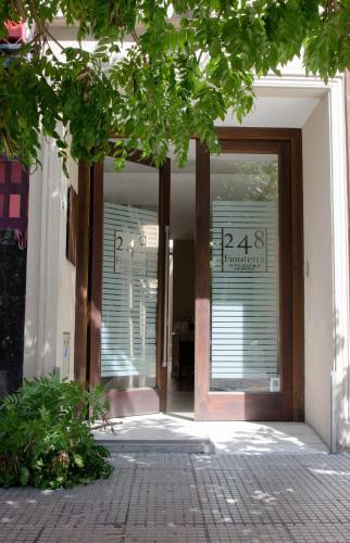 an open door of a building with windows and a sidewalk at 248 Finisterra in Buenos Aires