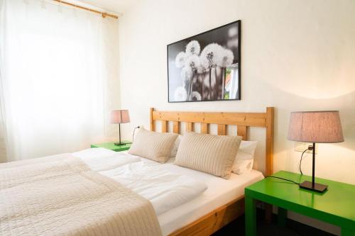 a bedroom with a bed and two green tables at Ferienhof Homann Sauerland in Brilon