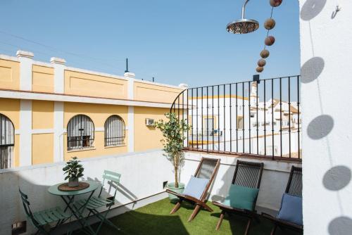 a balcony with chairs and a table on a building at Magno Apartments Guadalquivir Terrace in Seville