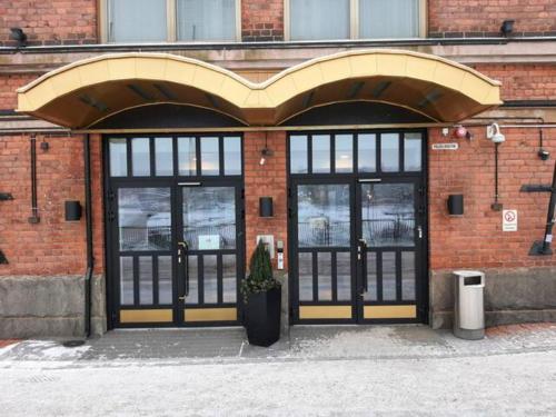 een bakstenen gebouw met zwarte en gele deuren bij Lapinniemen kattohuoneistot Tampereella in Tampere