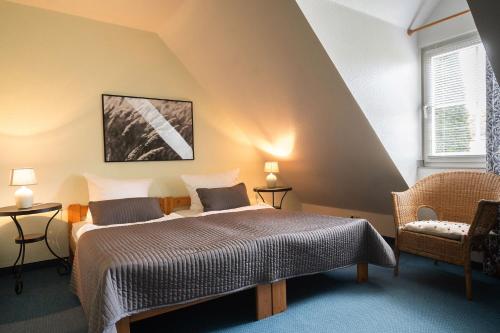 a bedroom with a bed and a chair and a window at Ferienhof Homann Sauerland in Brilon