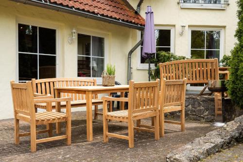 a group of wooden benches and a table and umbrella at Ferienhof Homann Sauerland in Brilon