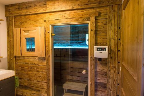 uma casa de banho com um chuveiro numa cabina de madeira em Chalet am Ölberg mit Badefass und Altholzsauna em Waldmünchen