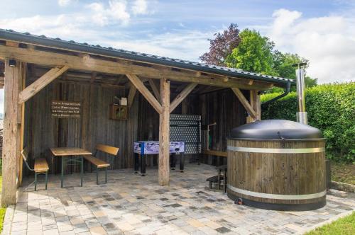 a wooden pavilion with a barrel and a table at Chalet am Ölberg mit Badefass und Altholzsauna in Waldmünchen