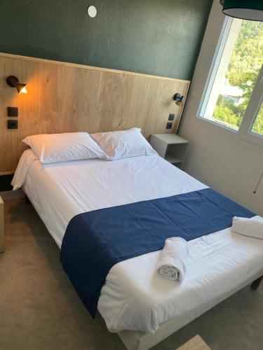 a bedroom with a large bed with blue and white sheets at Ô & Cimes in Saint-Pierre-dʼAlbigny