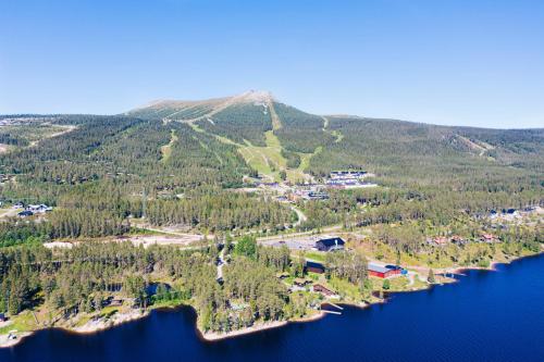 an island in the middle of a lake with a mountain at Lofsdalens Fjällhotell & Hotellbyns Lägenheter in Lofsdalen