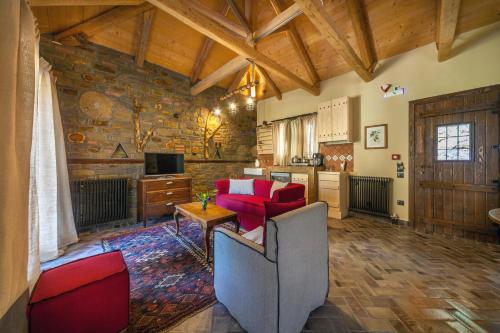 a living room with a couch and red chairs at Montanema Handmade Village in Platanákos