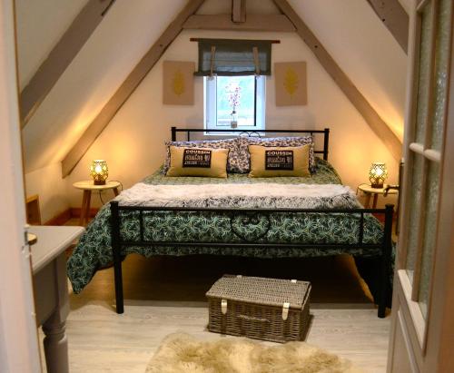 1 dormitorio con 1 cama en el ático en Le Vieux Moulin Gites - Detached cottage with garden views and pool, en Guégon
