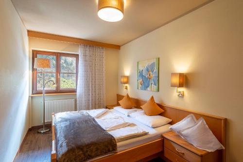a bedroom with a bed with pillows and a window at Alpenhof Lodge Ifinger in Saltusio