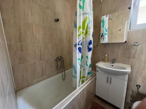 bagno con lavandino e tenda doccia di Апартамент Иванови a Pomorie