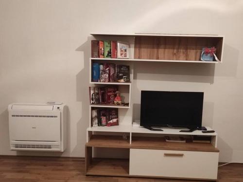 Modern apartment in Tirana في تيرانا: مكتب فيه تلفزيون وكمبيوتر في الغرفة