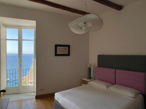 a bedroom with a bed and a view of the ocean at Casa a Mare in Sorrento