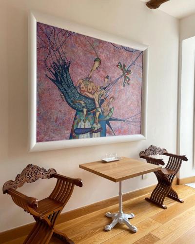 a table and two chairs in a room with a painting at Casa a Mare in Sorrento
